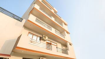 A multi-story building with balconies, windows, and air conditioning units.