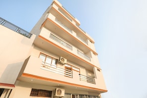 A multi-story building with balconies, windows, and air conditioning units. - Hotel O Elite Stay Inn (Lucknow)