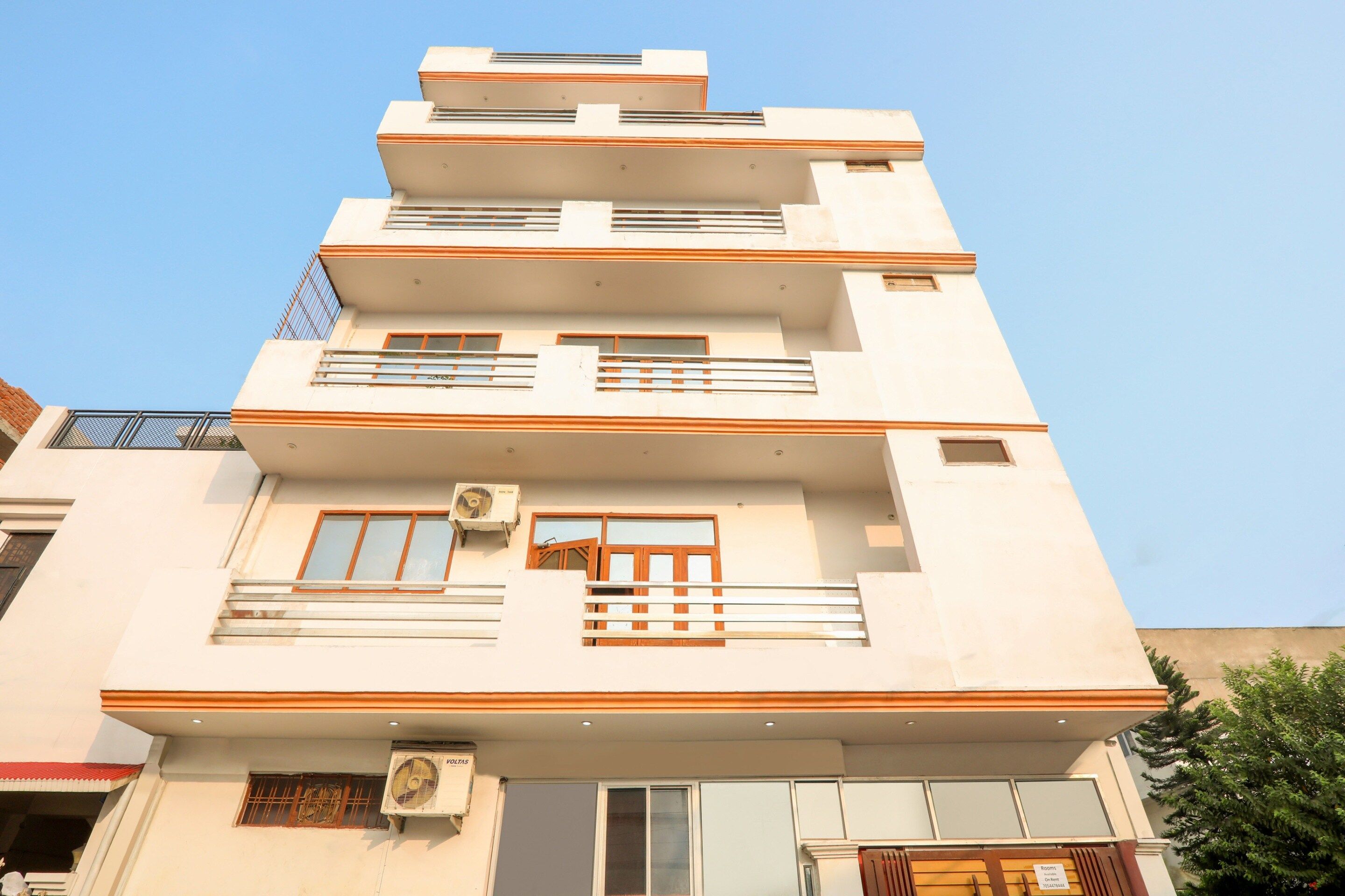 Un immeuble à plusieurs étages doté de balcons, de fenêtres et d’un appareil de climatisation.