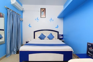 A hotel room with a bed, a nightstand, a wall-mounted air conditioner, a framed picture, and a sign with text. - HOTEL O JMD INN (Lucknow)