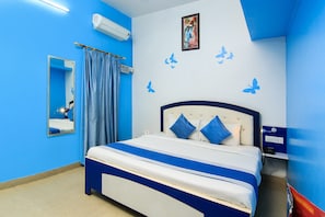 A bedroom with a bed, a mirror, an air conditioning unit, and a wall with butterfly decals. - HOTEL O JMD INN (Lucknow)