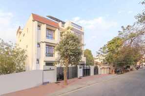 A multi-story building with a flat roof and a gated entrance. - HOTEL O JMD INN (Lucknow)
