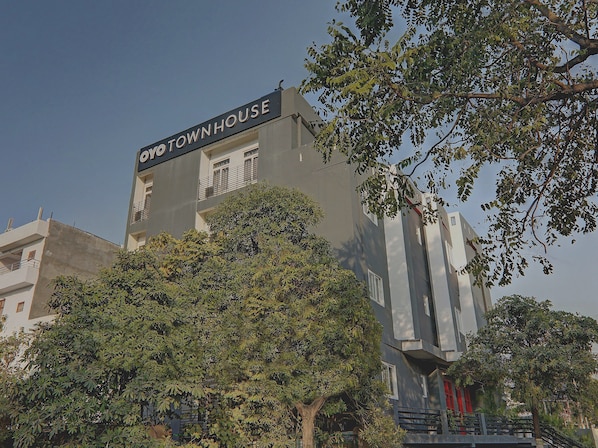 Un edificio con un cartello che riporta 'YO TOWN HOUSE' e un balcone con ringhiere.