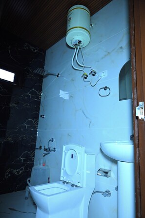 A bathroom with a toilet, sink, shower, and a water heater mounted on the wall. - Shimla Eco Village (Shimla)