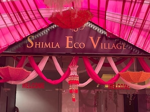A sign for Shima Eco Village with 'WELCOME' written on it.