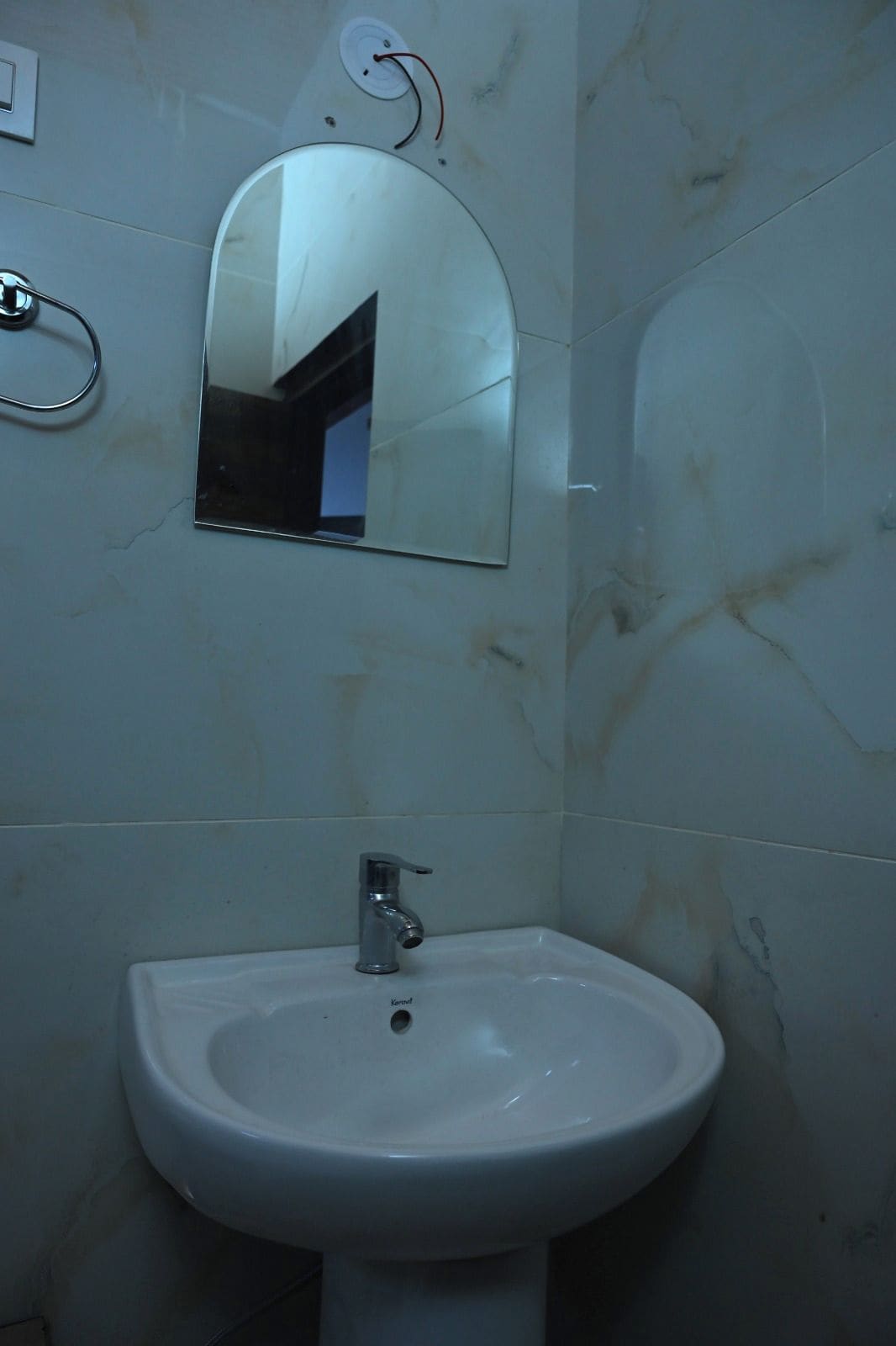 Un baño con un lavamanos blanco y un espejo.