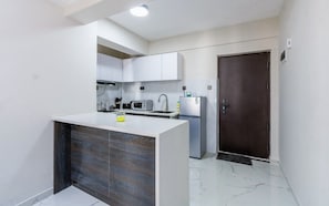 Een moderne keuken met witte kasten, een inbouw eiland en een magnetron.