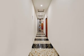 Un pasillo con piso de baldosas que conduce a una puerta.