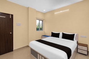 A bedroom with a bed, bedside tables, a wardrobe, and a window. - Hotel O Vaibhav Run Grand (Hyderabad)