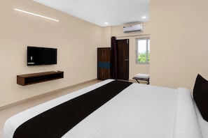 A modern hotel room with a large bed, a flat-screen TV mounted on the wall, a wardrobe, and an air conditioning unit. - Hotel O Vaibhav Run Grand (Hyderabad)
