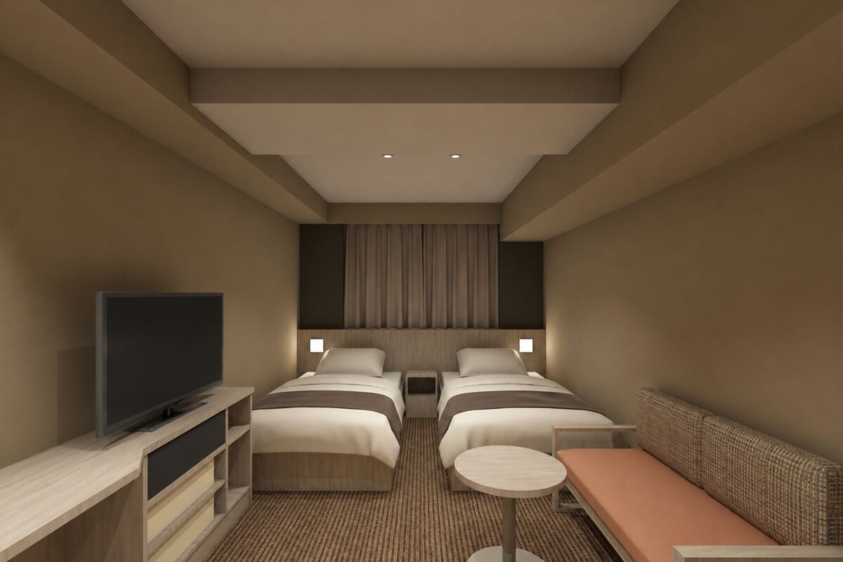 A hotel room with two beds, a television, a small table, and a sofa.