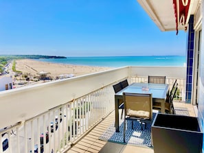 Ein Balkon mit Blick auf einen Strand und das Meer.