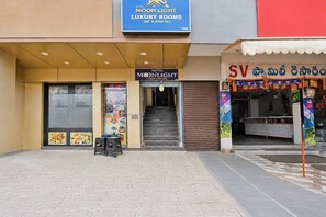 Entrada d'hotel amb un rètol que diu 'Moonlight Luxury Rooms' i una escala que hi mena.