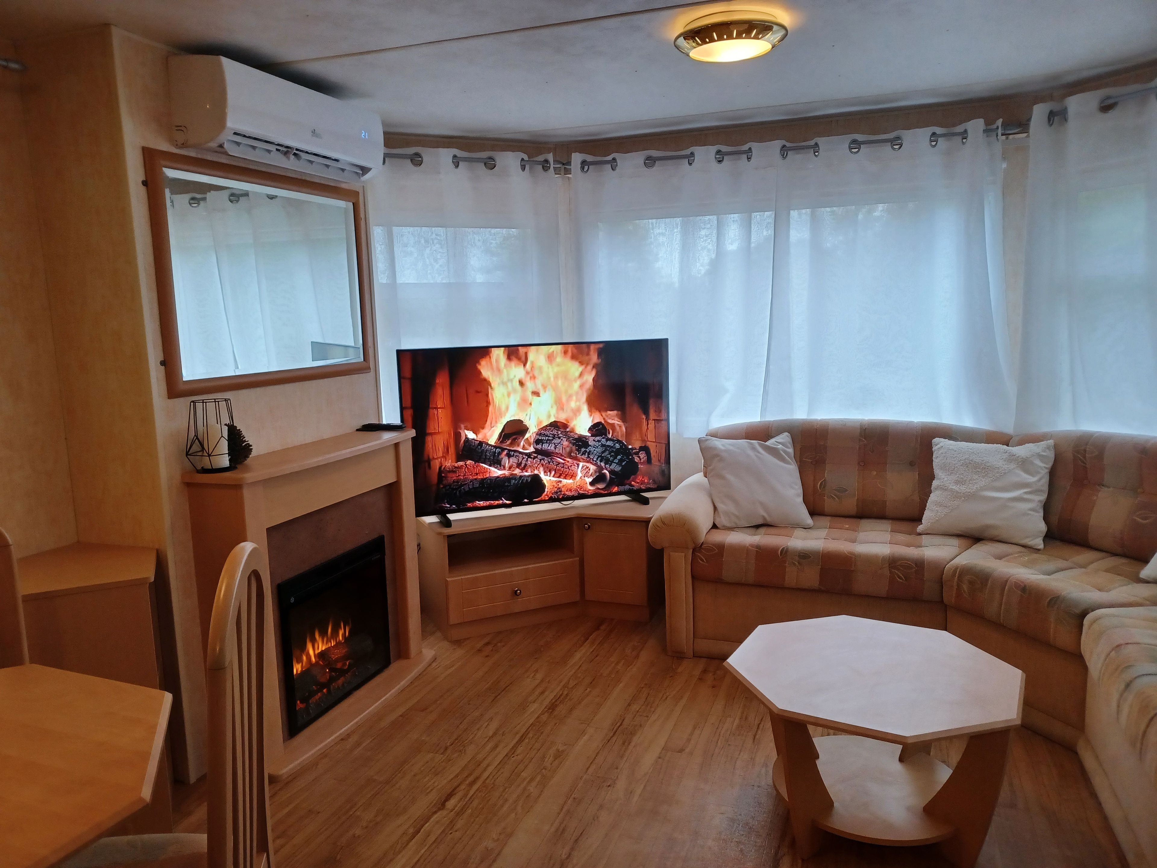 A living room with a fireplace, a television, a sofa, and a coffee table.