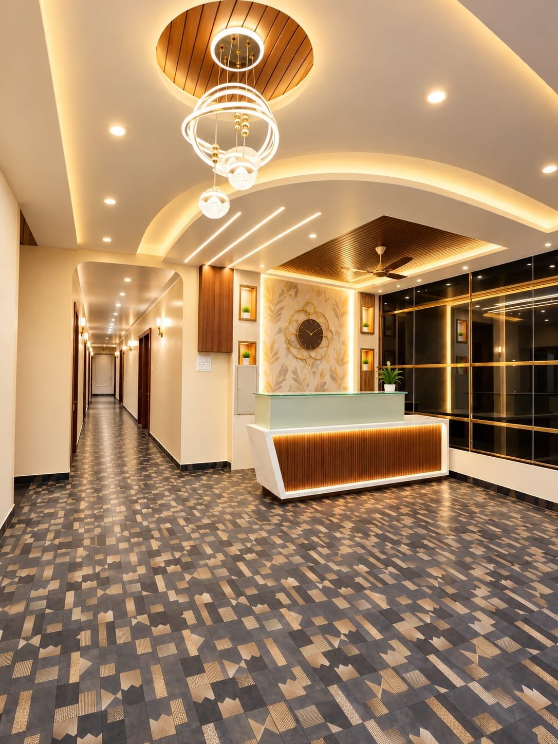 A hotel lobby with a reception desk, a patterned floor, and a ceiling with recessed lighting.