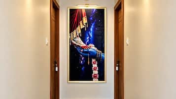 Ein Flur mit Musterfußboden, gerahmten Bildern an der Wand und Wandleuchten.