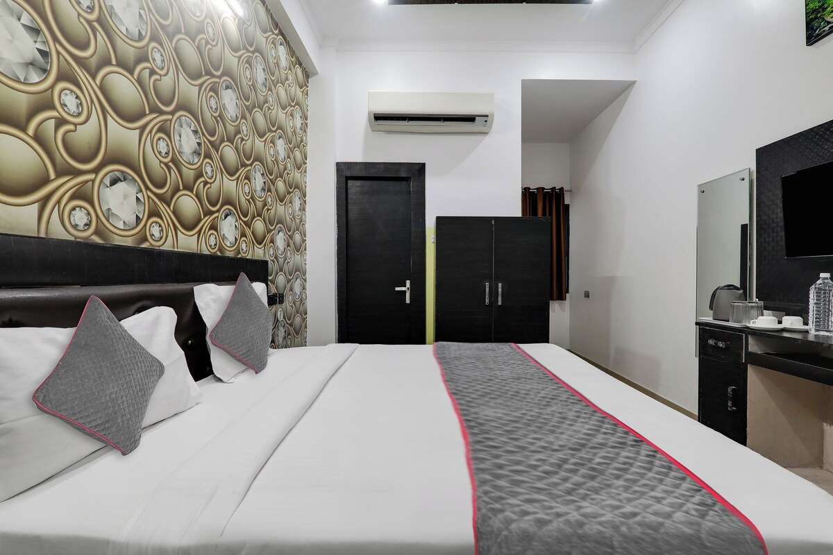 Een hotelkamer met een bed, een kledingkast, een spiegel en een airconditioner.