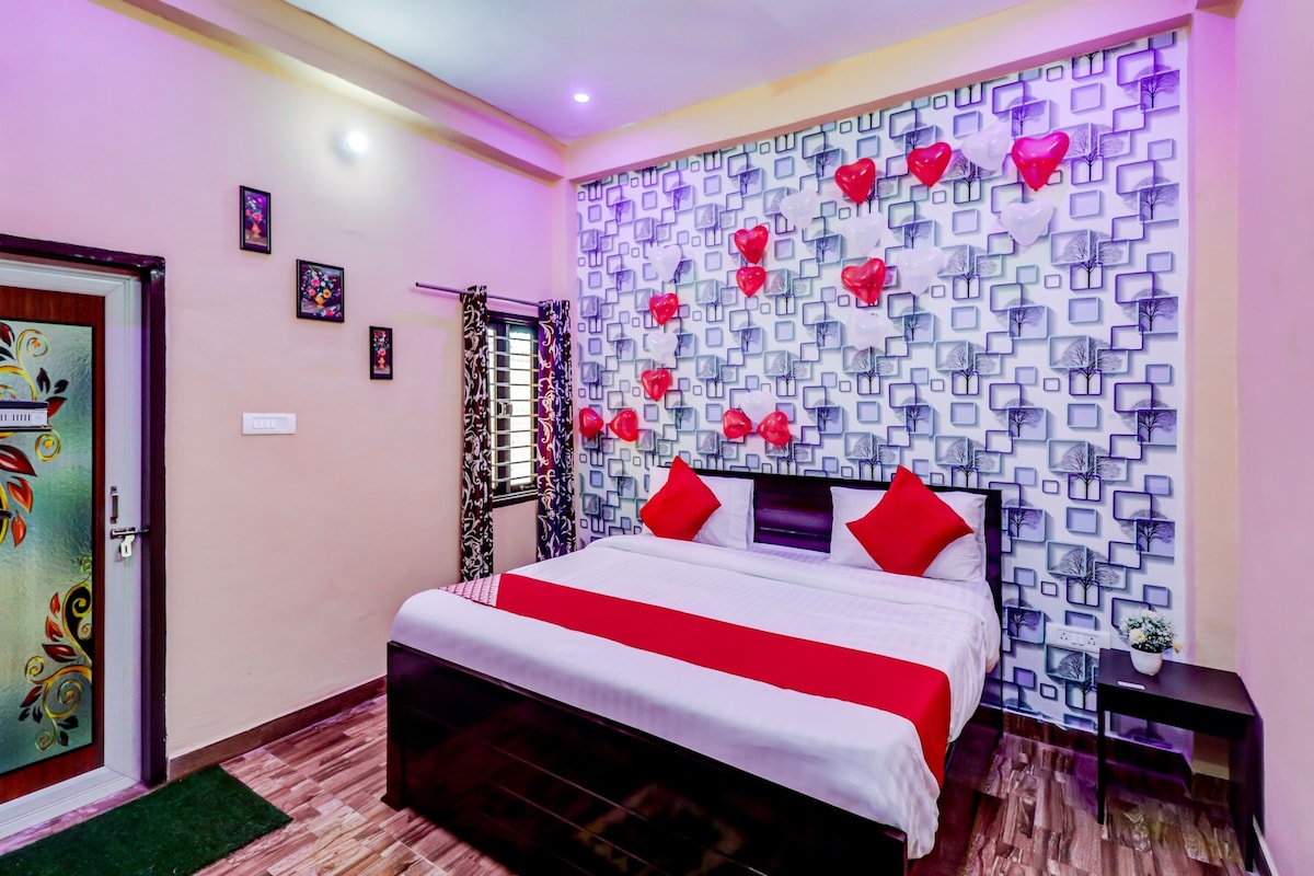 A bedroom with a bed, a wall with a geometric pattern, and a door with a floral design.