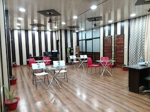 Una sala conferenze dal design moderno, con pavimento in legno, pareti a righe e ventilatori a soffitto.
