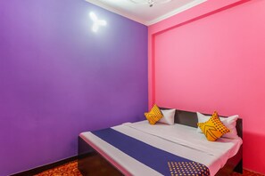 Una camera da letto con un letto, cuscini e un tappeto decorato.