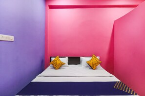 Una stanza piccola con un letto, due cuscini e una presa elettrica.