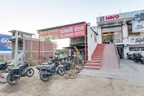 A hotel with a signboard, a staircase, and motorcycles parked in front. - Hotel O by OYO Rajdhani Hotel (Lucknow)