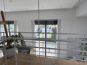 Una habitación con vistas a un jardín, ventanas amplias y una planta en maceta.