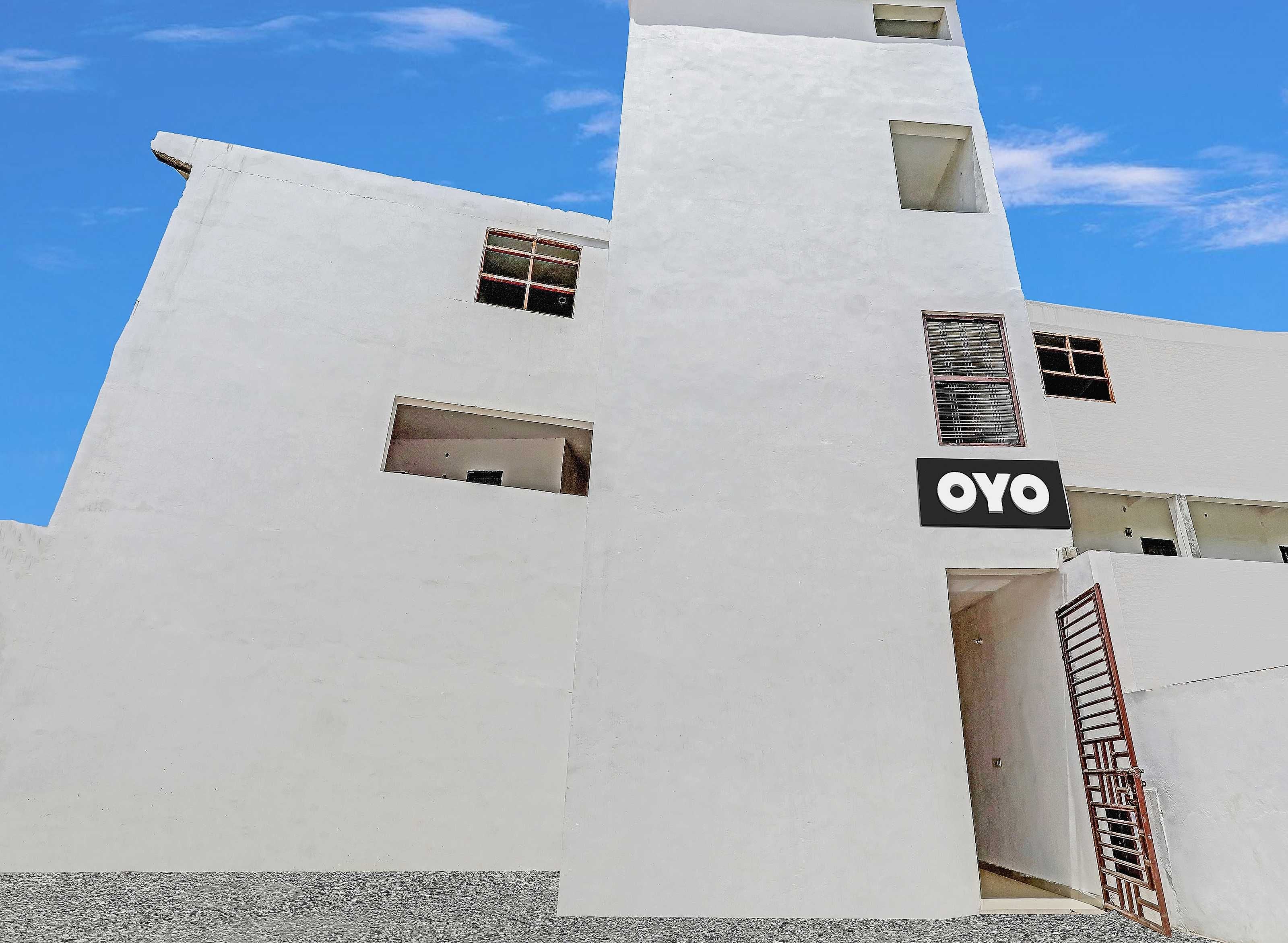 Ein Gebäude mit weißer Fassade, einem sichtbaren Fenster und einem Schild mit dem Text 'OYO'.