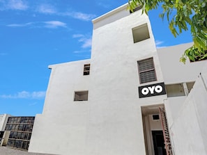 Un bâtiment blanc avec une enseigne indiquant « OYO » sur le côté.