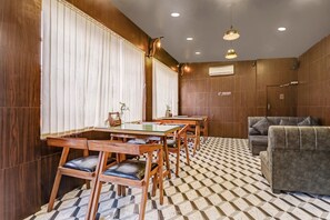 Een hotelkamer met een eethoek, een bank en een kamer met een patroon vloer.