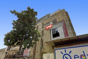 A building with a sign for 'OYO Rooms' indicating a hotel. There is a tree in front of the building, and a sign for a 'Star Stay Guest House' with 'AC & NON AC Rooms Available' is visible. - Hotel O Star Stay Guest house opposite (Lucknow)