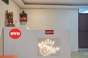 A reception area with a neon sign, a reception desk, and a wall-mounted shelf with a statue. - Hotel O Mr Crown Inn To Inn (Lucknow)