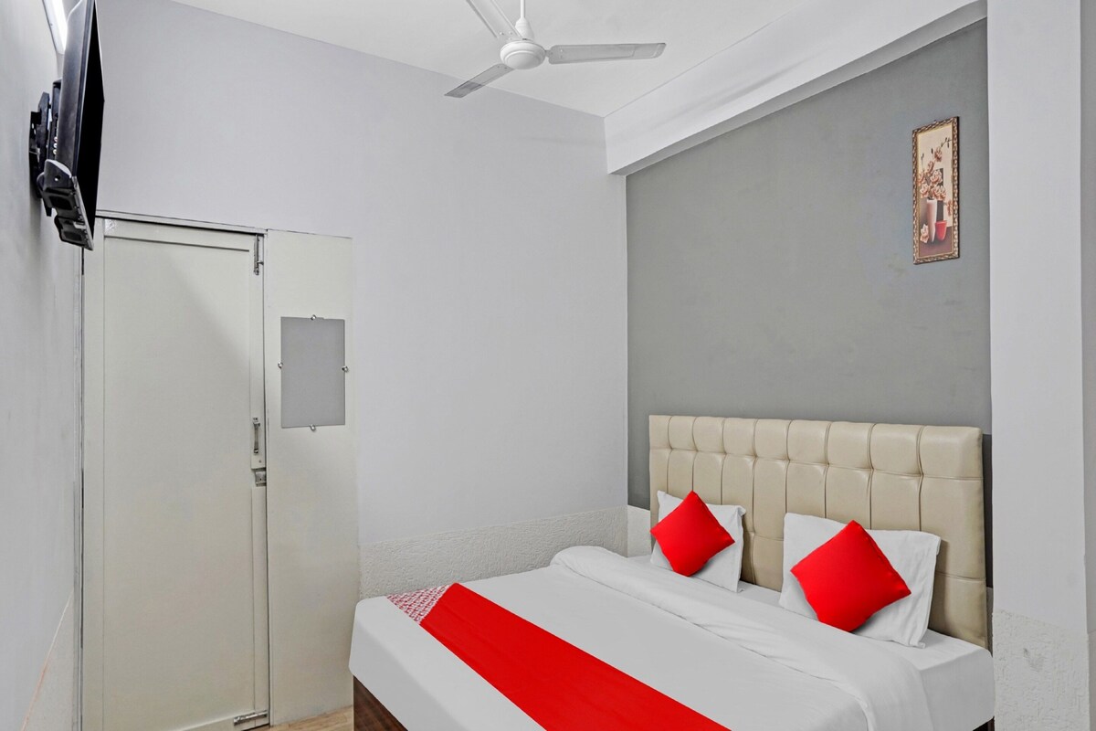 A hotel room with a bed, a ceiling fan, a door, and a framed picture on the wall.