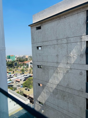 Un grattacielo con molte finestre e vista su un parcheggio e altri edifici sullo sfondo.
