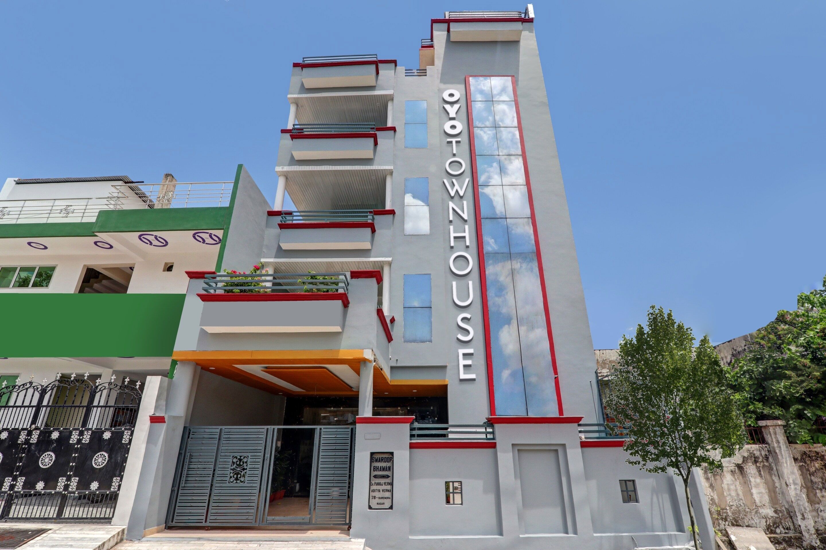 Un immeuble à plusieurs étages, sur lequel on peut voir une enseigne bien visible avec l’inscription « OYTOWNHOUSE ».