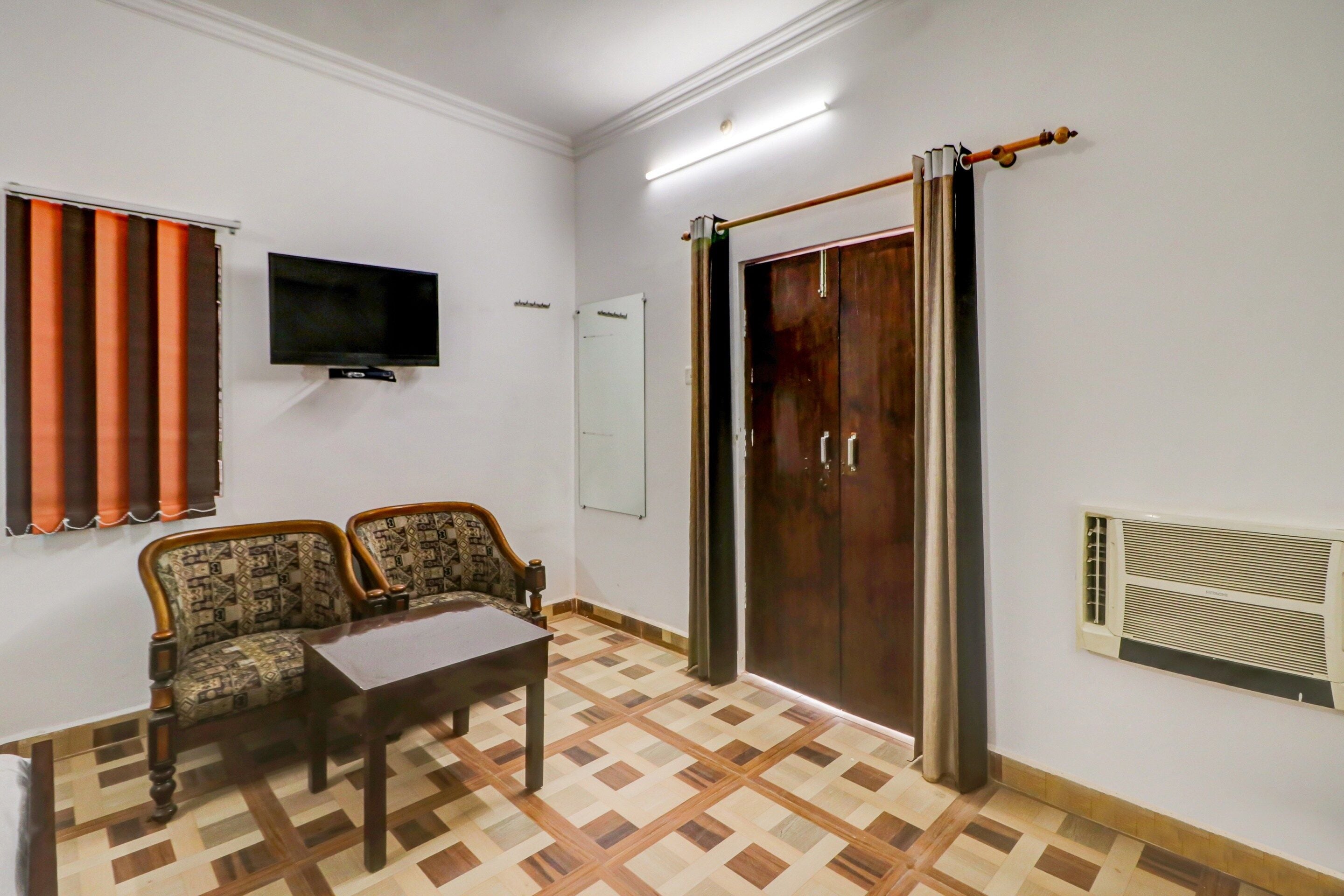 Una habitación con sofá, mesa, televisión, armario y radiador.