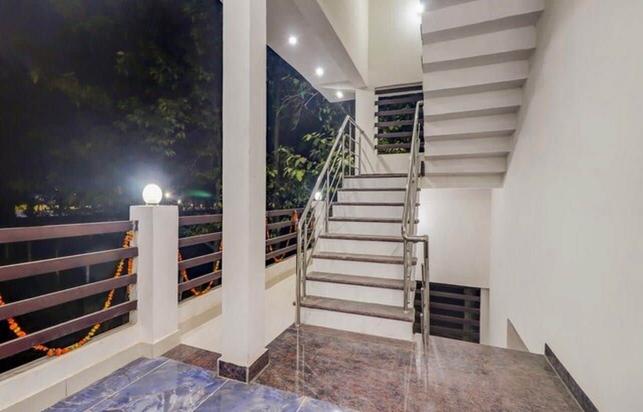 Escadaria com corrimãos e guarda-corpo, levando a um andar superior.