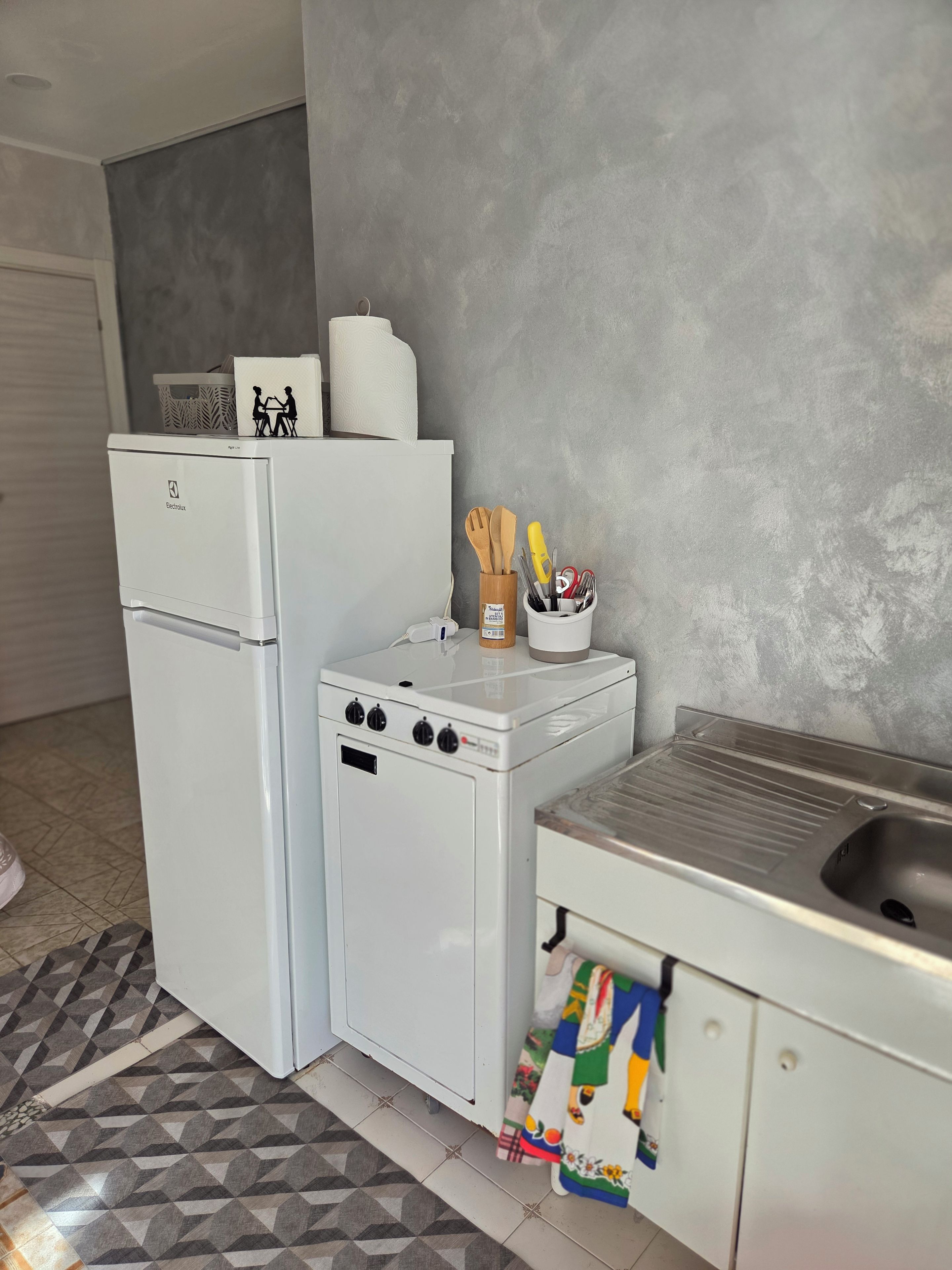Eine kleine Küche mit Kühlschrank, Herd und Spüle.