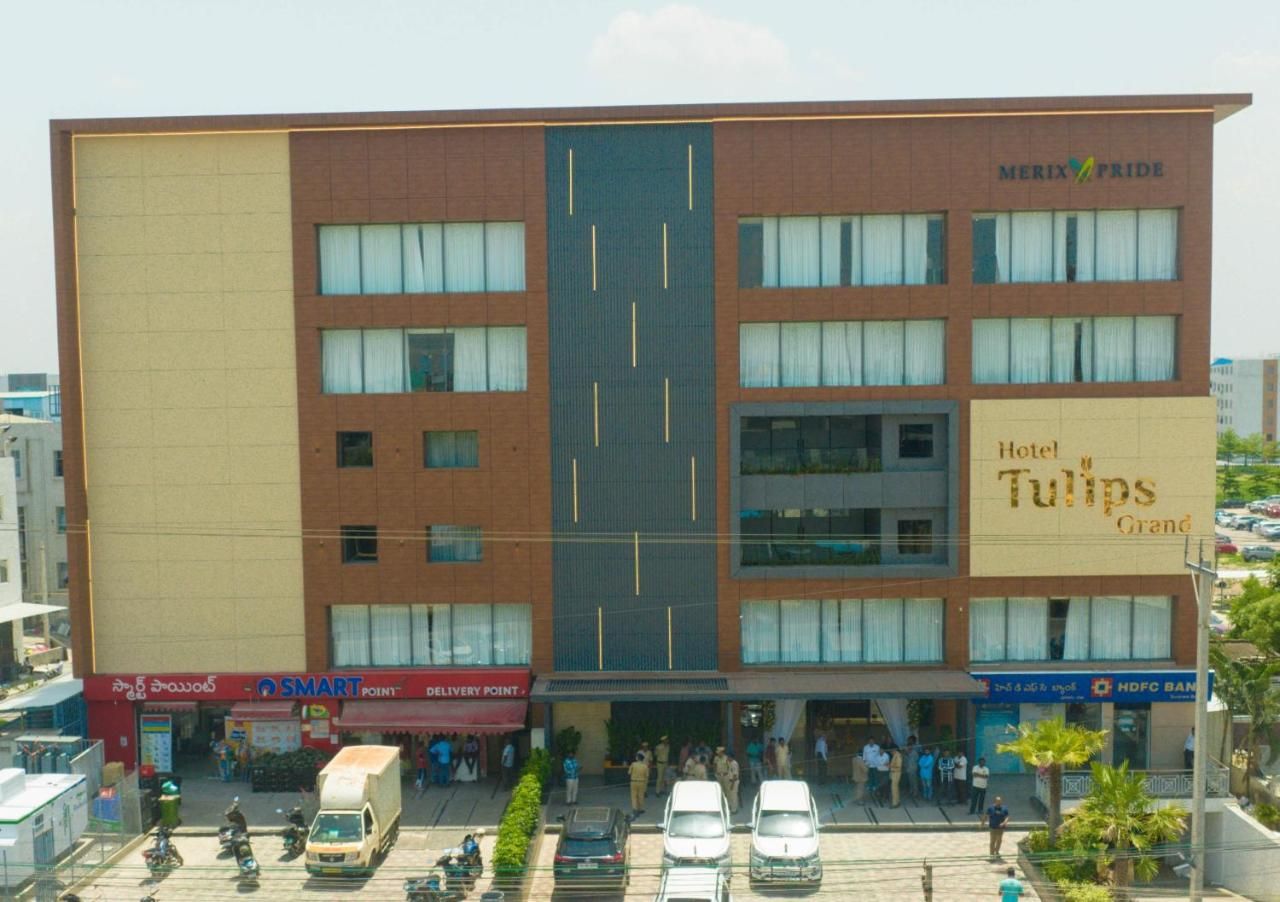 A hotel with multiple floors, a prominent sign for Hotel Tulips Grand, and a delivery point named SMART POINT.