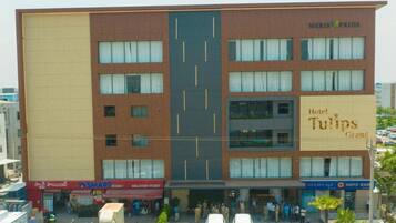 A hotel with multiple floors, a prominent sign for Hotel Tulips Grand, and a delivery point named SMART POINT.