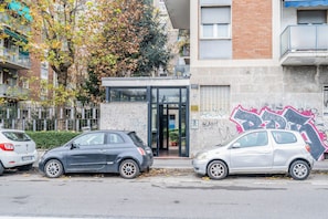 Un edificio con puerta de garaje, un cartel con el número 127 y una pared con grafitis.