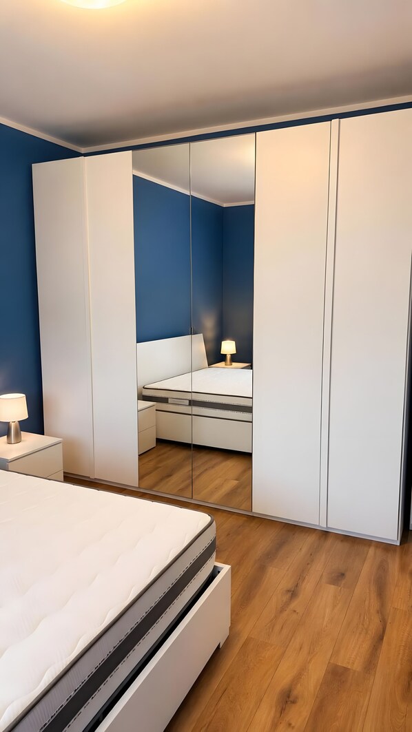 Una camera da letto moderna con un letto, un comodino e uno specchio.