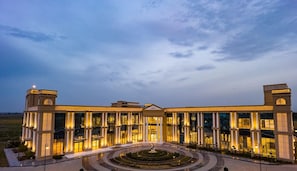 A large, classical building with multiple columns and a central entrance, surrounded by a circular garden. - Met City Club & Convention Centre (Yakubpur)