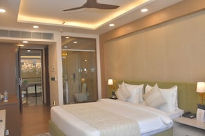 A hotel room with a bed, bedside tables, a desk, and a chair. - Met City Club & Convention Centre (Yakubpur)