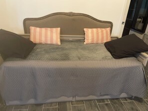 Ein Bett mit Kopfteil, zwei Kissen und einer Decke.