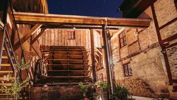 A rustic outdoor staircase leading to a wooden building with a starry night sky above.