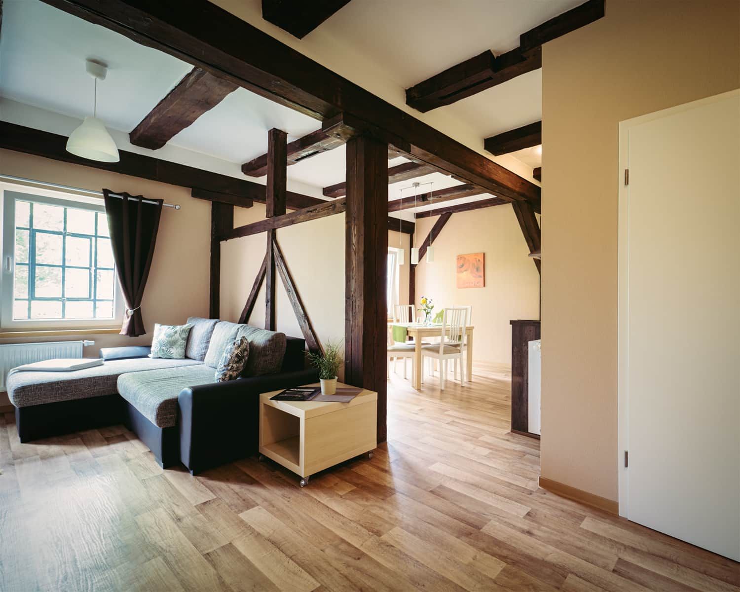 Ein Zimmer mit einem Bett, einem kleinen Tisch und einer Essecke mit Stühlen.