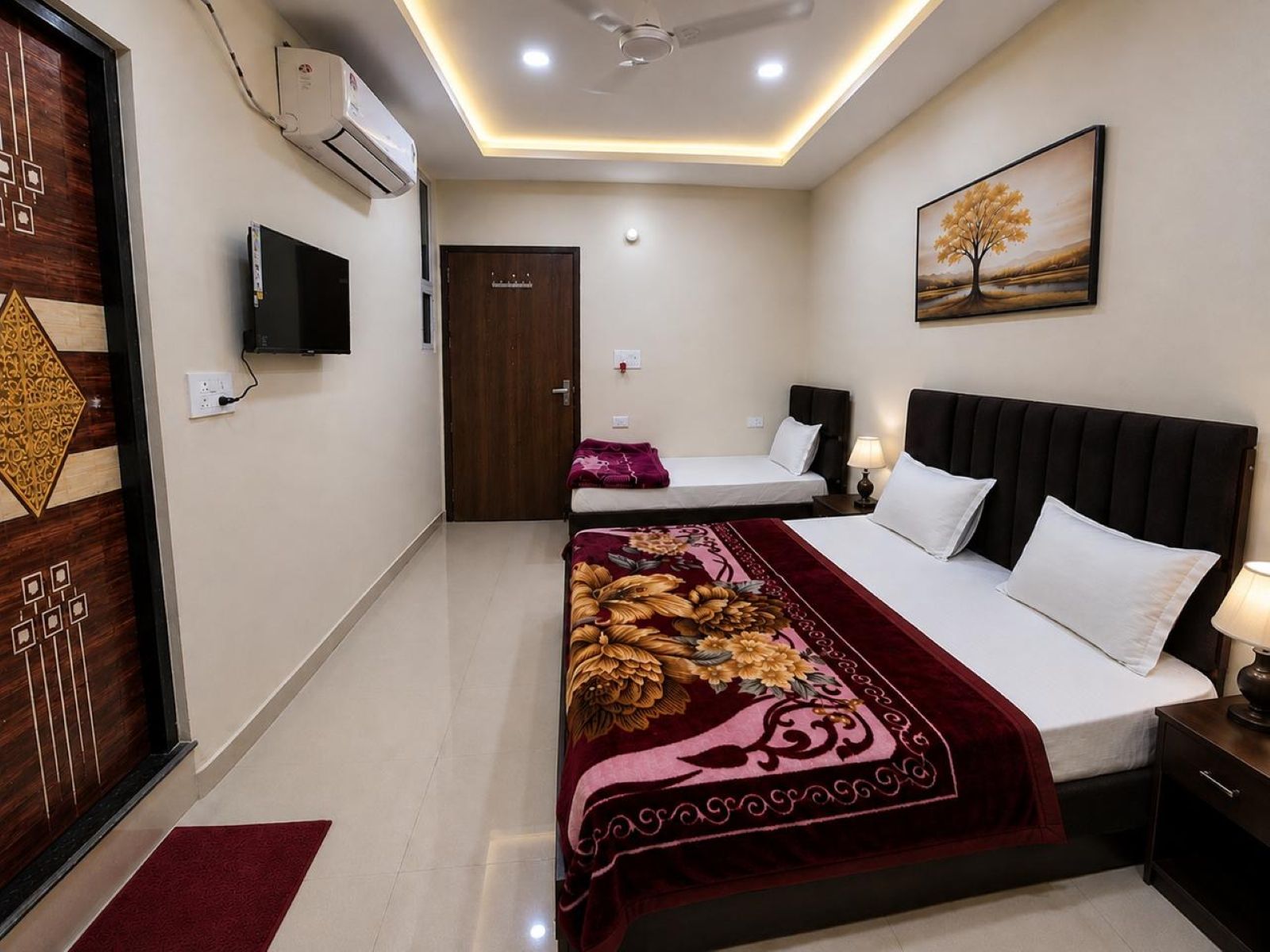 A hotel room with a bed, bedside tables, a TV, and a door.