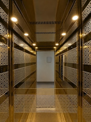 A modern elevator interior with patterned walls and ceiling lights. - Hotel Kanha Residency (Mathura)