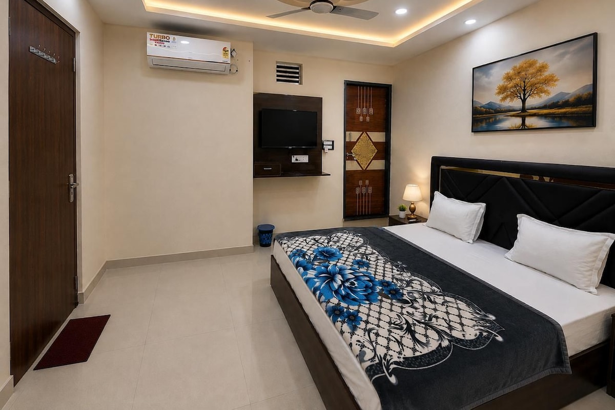 Ein Schlafzimmer mit einem Bett, einem Fernseher, einem Deckenventilator und einem Gemälde an der Wand.